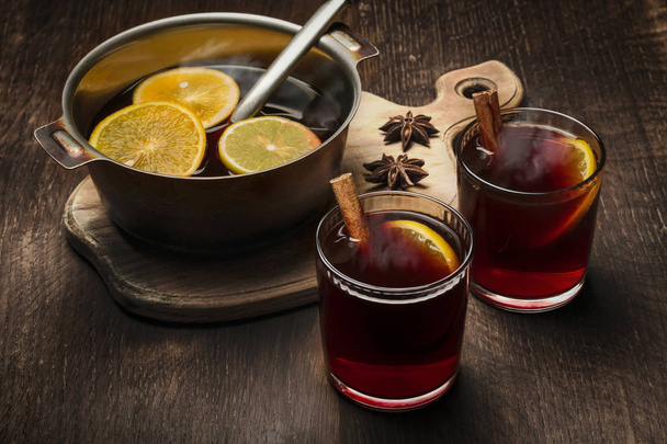 Glasses with hot mulled wine and a bowl for the preparation of a beverage. - Photo, Image