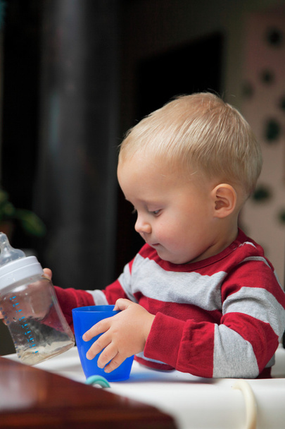 baby boy playing with bottle and mug indoor - Photo, Image