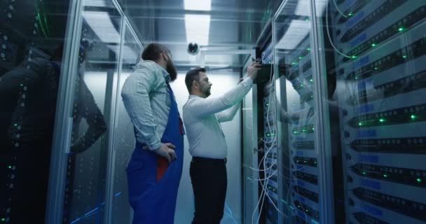 Kaksi miestä suorittaa ylläpitoa datakeskuksessa
 - Materiaali, video