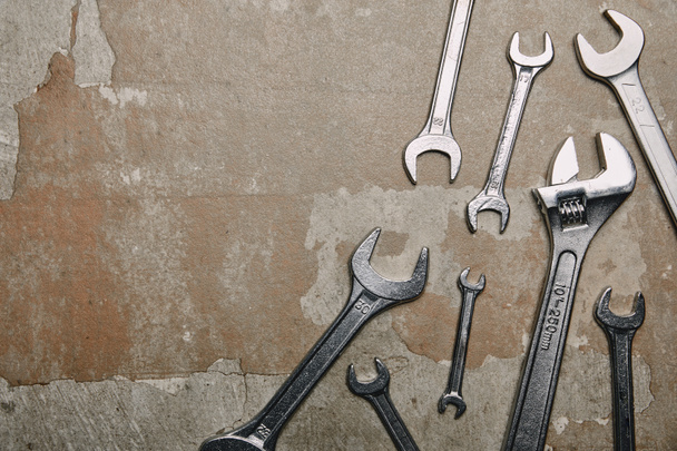 Top view of different wrenches and one monkey wrench on the background of old  surface - Valokuva, kuva