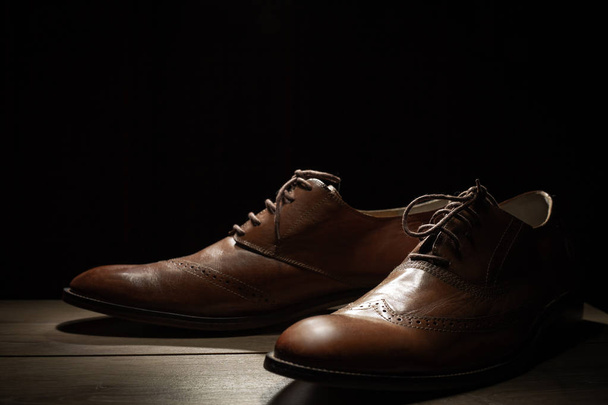 męskie brązowy buty na czarnym tle  - Zdjęcie, obraz
