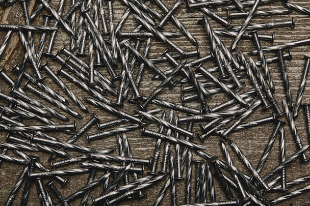 Top view of nails arranged on wooden table - Фото, зображення