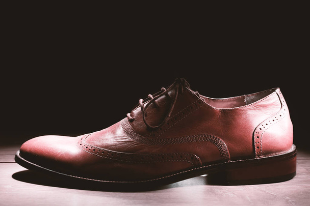 brązowy buty męskie na ciemnym tle  - Zdjęcie, obraz