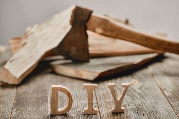 Close up of diy sign on wooden table on the background of logs and axe - Fotoğraf, Görsel