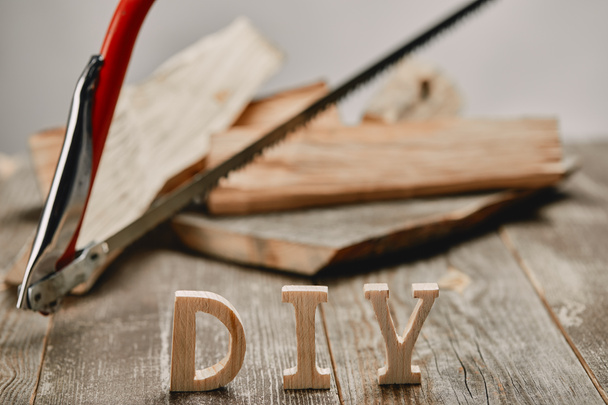 Close up of diy sign on wooden table on the background of logs and hacksaw - 写真・画像