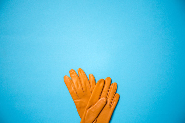 żółty rękawice na niebieskim tle, miejsce - Zdjęcie, obraz
