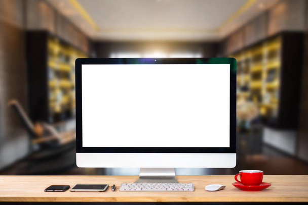 Espaço de trabalho com monitor de computador, teclado, smartphone copo de café de tela em branco e tablet em uma mesa ou tela branca isolada no interior da sala de escritório brilhante
. - Foto, Imagem