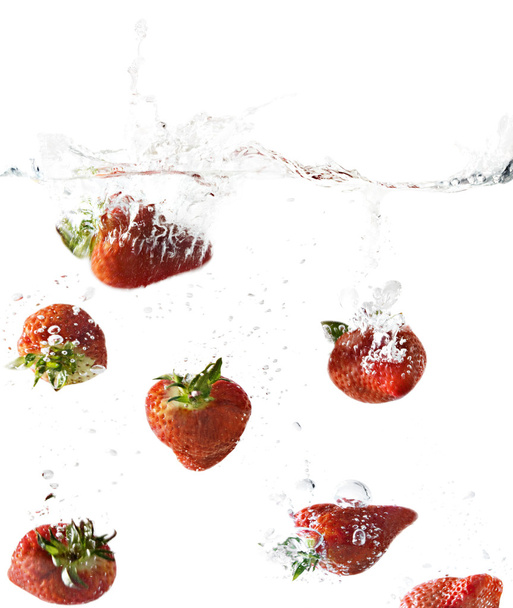 Vista lateral de fresas cayendo en agua clara
 - Foto, Imagen