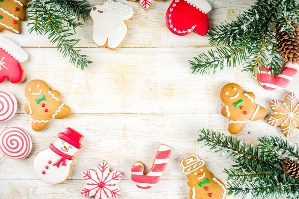 Kerstkoekjes met feestelijke decoratie op witte houten achtergrond bovenaanzicht kopiëren ruimte - Foto, afbeelding