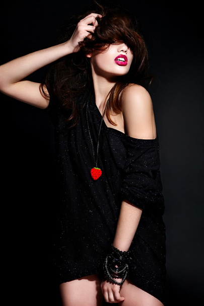 glamor portrait of beautiful sexy stylish Caucasian young brunette woman model in black cloth with bright makeup with accessories with perfect clean skin with curly healthy hair with red lips - Fotó, kép