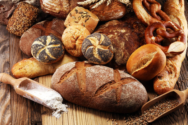 Diferentes tipos de pan y panecillos a bordo desde arriba. Cocina o panadería diseño de póster
. - Foto, imagen