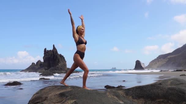 Meisje doet yoga balanceren op één been staan op een steen. Gemoedsrust. Gezonde levensstijl. Evenwicht en harmonie, vrede en vloeiende bewegingen - Video