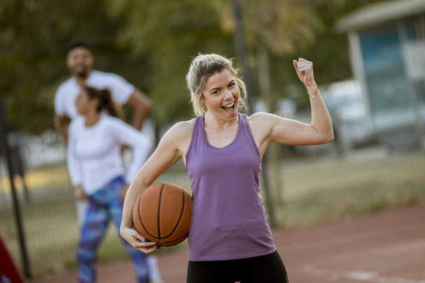 Retrato de fitness jovem com bola de basquete jogando jogo ao ar livre
 - Foto, Imagem