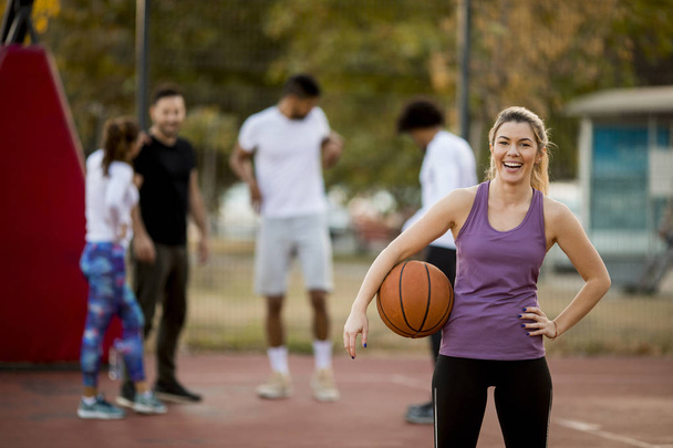 Retrato de fitness jovem com bola de basquete jogando jogo ao ar livre
 - Foto, Imagem