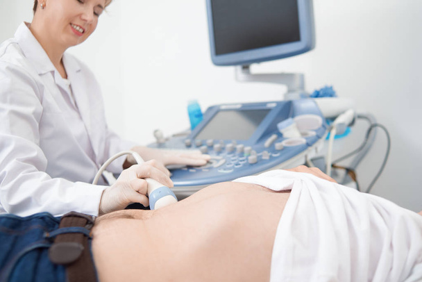 Physician doing ultrasound diagnostics to male patient. - Fotoğraf, Görsel