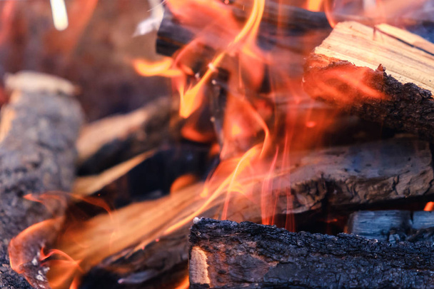 Pile of wood cut for fireplace, firewood with fire and smoke - Foto, imagen