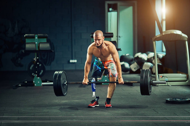Disabled young man training in the gym. - 写真・画像