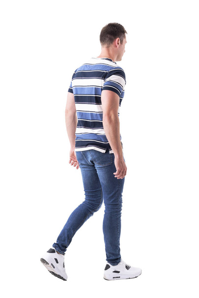 Vista lateral de un joven hombre adulto casual en jeans alejándose. Cuerpo completo aislado sobre fondo blanco
.  - Foto, imagen