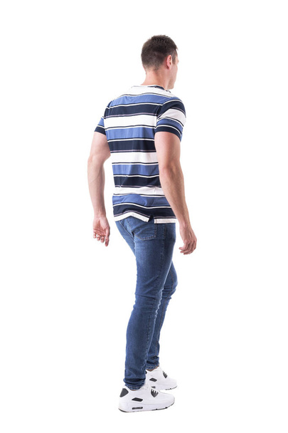 Vista lateral trasera del hombre adulto joven casual caminando o saliendo mirando hacia otro lado. Cuerpo completo aislado sobre fondo blanco
.  - Foto, imagen