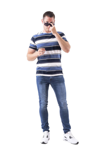 Cool knappe volwassen man zonnebril met vinger druk aan te passen. Volledige lichaam geïsoleerd op witte achtergrond.  - Foto, afbeelding