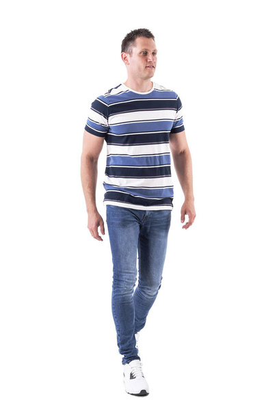 Cool relaxed casual man wearing t-shirt and jeans walking casually. Full body isolated on white background.  - Фото, изображение