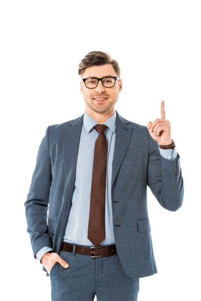 cheerful businessman in glasses and suit pointing upwards isolated on white - Фото, зображення