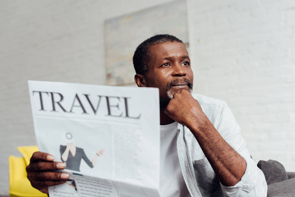 dreaming african american man reading travel newspaper  - Valokuva, kuva