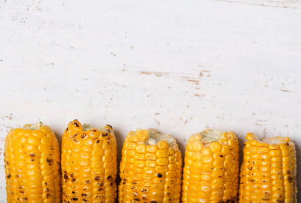 Grilled corn cobs on the rustic background. Top view with horizontal copy space - 写真・画像
