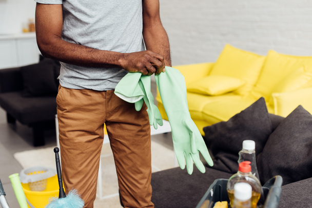 cropped view of african american man putting rubber gloves - Photo, Image
