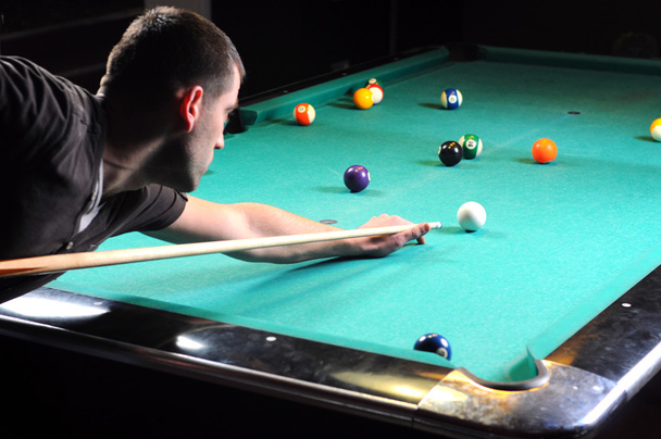 Mann spielt Snooker im dunklen Club - Foto, Bild