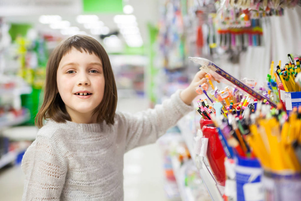 first grader buying pens and pencils in   bookstor - Foto, Imagen