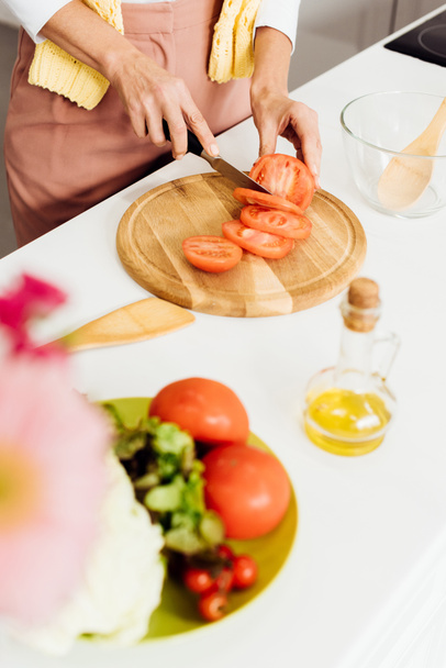 κοντινό πλάνο γυναικεία χέρια κοπής ντομάτα για σαλάτα - Φωτογραφία, εικόνα