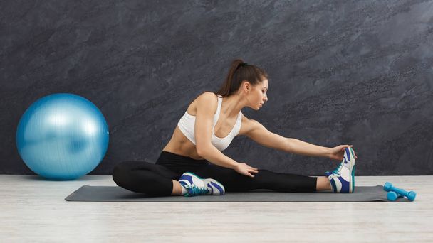 Fitness woman stretching indoors - Фото, изображение