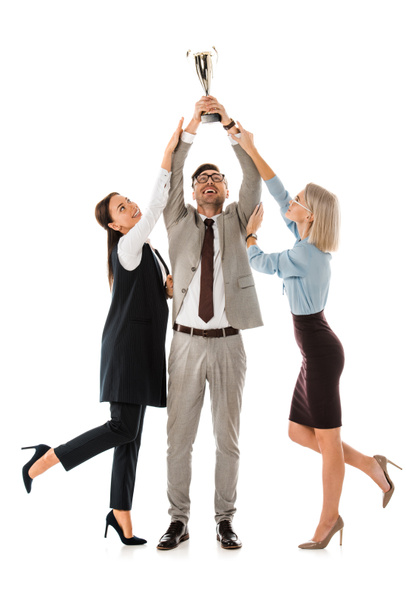 Erfolgreicher Geschäftsmann hält Pokal in die Höhe, während weibliche Kollegen versuchen, ihn auf Weiß zu isolieren - Foto, Bild