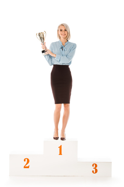 успішна бізнес-леді з кубком трофею, що стоїть на подіумі переможців ізольовано на білому
 - Фото, зображення