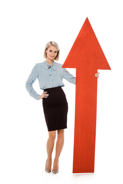 young businesswoman standing with big red arrow isolated on white - Photo, Image