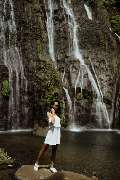 stylish young woman taking picture for social media in waterfall - Foto, Imagen