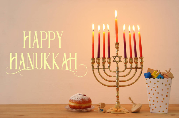 Image of jewish holiday Hanukkah background with traditional spinnig top, menorah (traditional candelabra) and burning candles - Фото, изображение