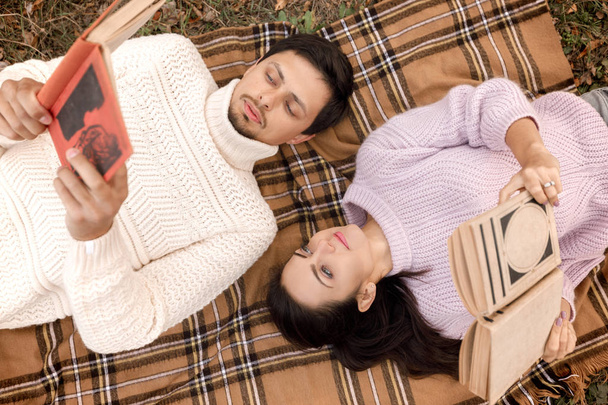 pareja enamorada sentada en el parque de otoño y leyendo libro
 - Foto, imagen