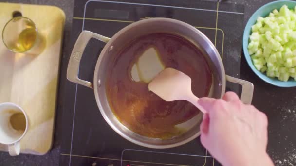 Χέρια του ζαχαροπλάστη προσθέτοντας τα μήλα σε λιωμένη ζάχαρη - Πλάνα, βίντεο