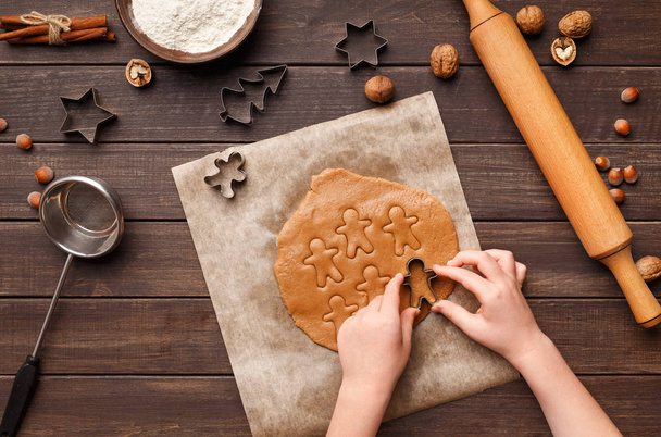 Child hands cutting gingerbread with metal cutters - Foto, immagini