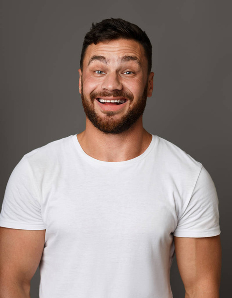 Smiley kerel in wit t-shirt studio portret - Foto, afbeelding