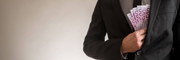 Szeroki kąt widzenia obrazu biznesmen wprowadzenie 500 Euro rachunki w kieszeni kurtki elegancki garnitur. Z miejsca kopii po lewej stronie obrazu. - Zdjęcie, obraz