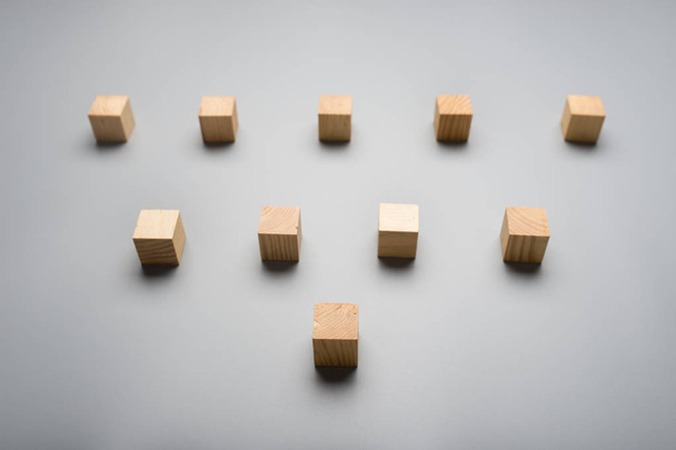 Dix cubes en bois vierges placés sur fond gris en forme de triangle
. - Photo, image