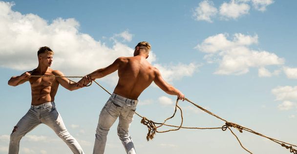 Treating your team like a family. Strong men pull ropes. Athletic twins with fit sexy body. Twins men use muscular hand strength. Sport exercises for building strength and power - Foto, Bild