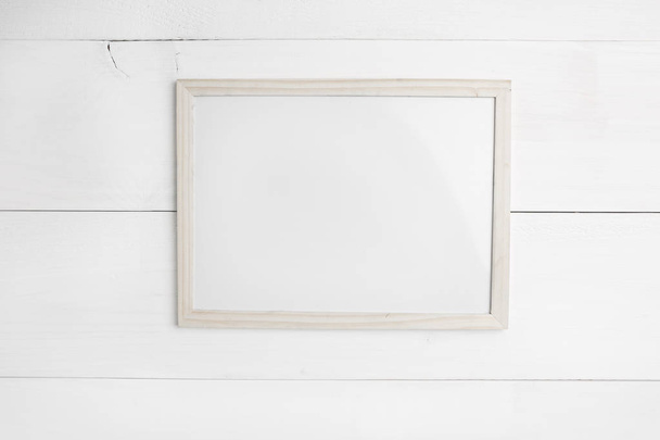 Small empty wooden frame on white wooden background - Фото, зображення
