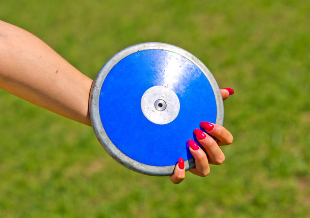 blue disc close to a hand with red fingernails ready to be launched - Fotó, kép