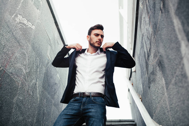 Young stylish businessman man with a beard in a fashionable suit and jeans. - 写真・画像