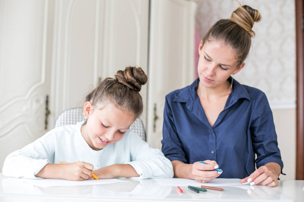 Happy family. Mother and daughter together paint and draw. Adult woman helps the child girl - Photo, image