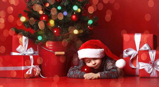 Tijdens de kerstnacht een jongetje wachten op Santa Claus. kleine jongen dromen van Kerstmis. - Foto, afbeelding